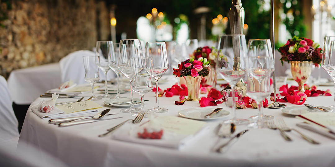 romantyczny stół weselny ozdobiony różami z pełną zastawą